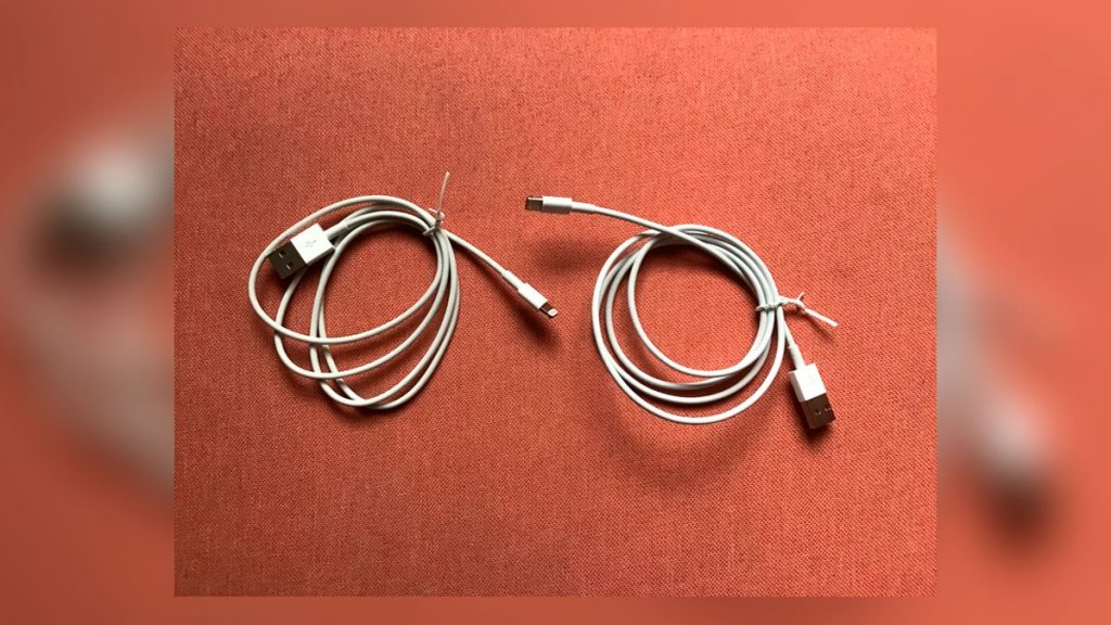 Due cavi USB sono avvolti uno accanto all'altro sotto un tappeto, solo uno di loro ruba le password
